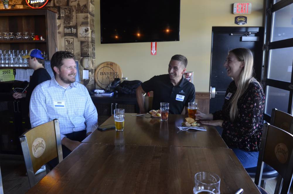 Three Seidman Alumni having a laugh at Social held at Founders Brewing